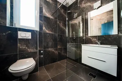 a bathroom with a toilet and a sink and a mirror at David Lux beach rooms in Dobra Voda