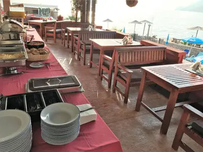 a restaurant with tables and chairs and the ocean at David Lux beach rooms in Dobra Voda
