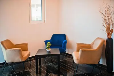 three chairs and a table in a waiting room at David Lux beach rooms in Dobra Voda
