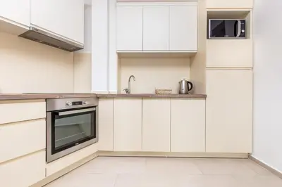 a kitchen with white cabinets and a sink at Apartment with sea view BEATRICE#26 in Rafailovici