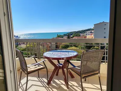 a table and chairs on a balcony with a view of the ocean at Adriatic Horizont Apartment in Petrovac na Moru