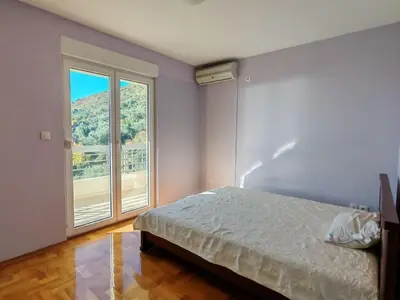 a bedroom with a bed and a large window at Adriatic Horizont Apartment in Petrovac na Moru
