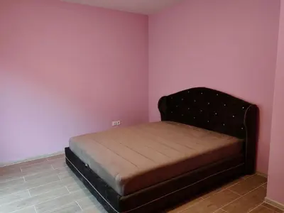 a small bed in a room with pink walls at Adriatic Horizont Apartment in Petrovac na Moru