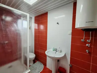 a red and white bathroom with a toilet and a sink at Adriatic Horizont Apartment in Petrovac na Moru