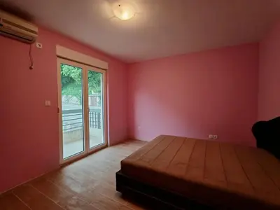 a bedroom with a bed and a sliding glass door at Adriatic Horizont Apartment in Petrovac na Moru