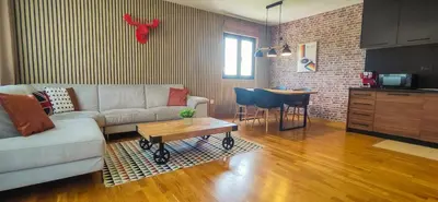 a living room with a couch and a table at Apartments Overlooking the Green Hills of Ljubovic Park in Podgorica