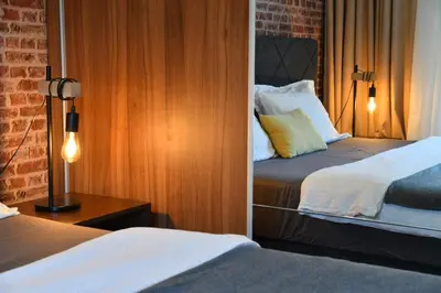 a bedroom with two beds and a lamp on a table at Apartments Overlooking the Green Hills of Ljubovic Park in Podgorica