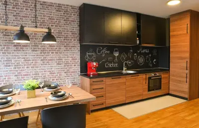 a kitchen with wooden cabinets and a brick wall at Apartments Overlooking the Green Hills of Ljubovic Park in Podgorica
