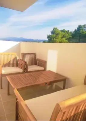a balcony with a table and chairs on a balcony at Apartments Overlooking the Green Hills of Ljubovic Park in Podgorica