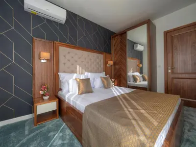 a hotel room with a large bed and a mirror at Garden Recovery in Sveti Stefan