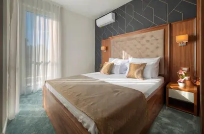 a hotel room with a large bed and a window at Garden Recovery in Sveti Stefan