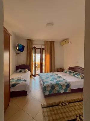 a hotel room with two beds and a balcony at Apartments Albin in Ulcinj