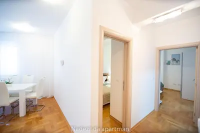 a white room with a table and a mirror at Marina Becici in Becici