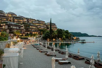 a beach with chairs and umbrellas next to the water at Sea View Villas in Duklei in Budva