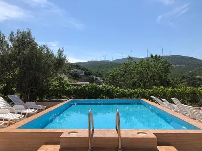 a swimming pool with a bunch of chairs at Open Sky Apartments in Utjeha