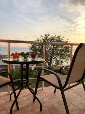 a table and chairs on a balcony with a bowl of fruit at Open Sky Apartments in Utjeha