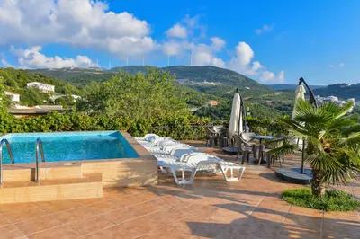 a swimming pool with lounge chairs and umbrellas at Open Sky Apartments in Utjeha