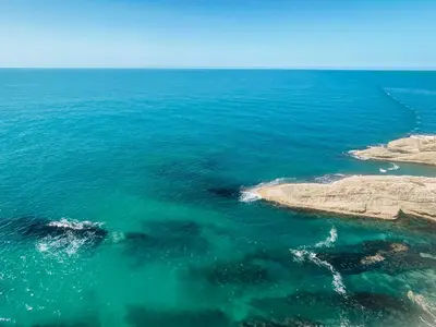 an aerial view of the ocean near a rocky shore at Open Sky Apartments in Utjeha