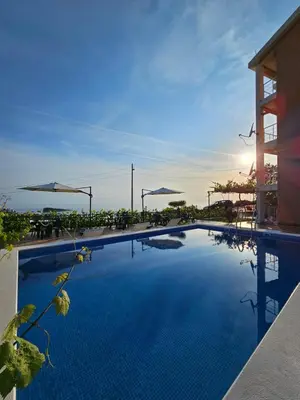 a large swimming pool next to a building at Open Sky Apartments in Utjeha