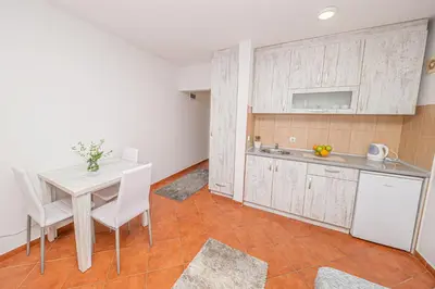 a kitchen with a table and a sink and a counter at Open Sky Apartments in Utjeha