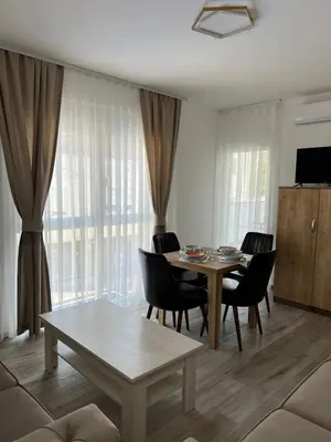 a living room with a dining room table and chairs at Relax Apartmani in Sutomore