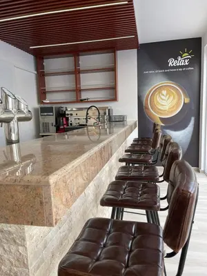 a row of leather bar stools in a coffee shop at Relax Apartmani in Sutomore