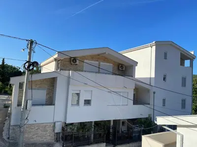 a white building with a lot of windows at Relax Apartmani in Sutomore