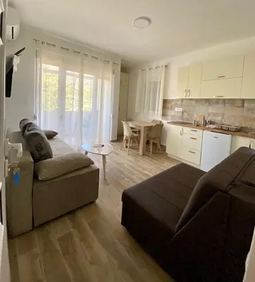 a large living room with a couch and a kitchen at Relax Apartmani in Sutomore