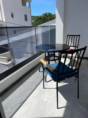 a table and a chair on a balcony at Relax Apartmani in Sutomore