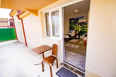a room with a table and a chair on a balcony at Simo apartments airport Podgorica in Podgorica