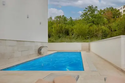 an indoor swimming pool with blue water in a building at Garni Hotel Larimar in Budva