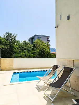 a pair of chairs sitting next to a swimming pool at Garni Hotel Larimar in Budva
