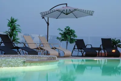a group of chairs and an umbrella next to a swimming pool at Spa Resort Bečići in Budva