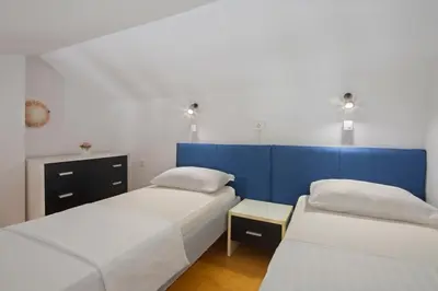a bedroom with two beds and a blue wall at Spa Resort Bečići in Budva