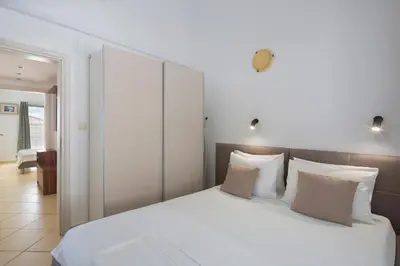 a bedroom with a large bed with white sheets and pillows at Spa Resort Bečići in Budva