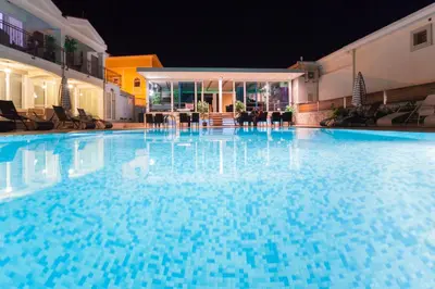 a large blue swimming pool at night at Spa Resort Bečići in Budva