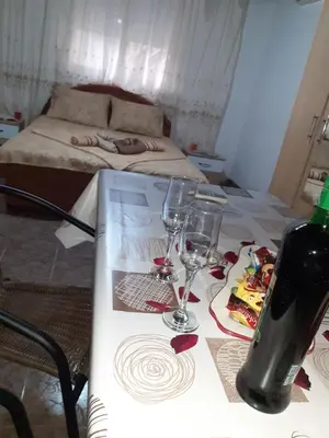 a table with wine glasses on it with a bed at Studio-apartman Milena 2 in Podgorica