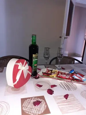 a table with a bottle of wine and a table with glasses at Studio-apartman Milena 2 in Podgorica