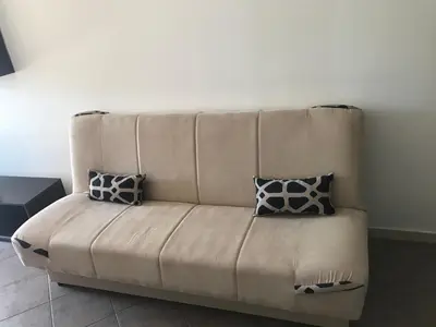 a couch with two pillows on it in a room at Apartman Odisej in Petrovac na Moru