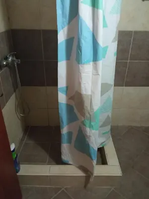 a shower with a blue and white shower curtain at Apartman Odisej in Petrovac na Moru