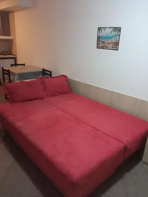 a large red bed sitting in a room at Apartman Odisej in Petrovac na Moru