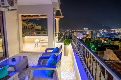a balcony with blue chairs and a view of the city at Villa Danigo in Budva