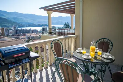 a table and chairs on a balcony with a grill at Villa Danigo in Budva