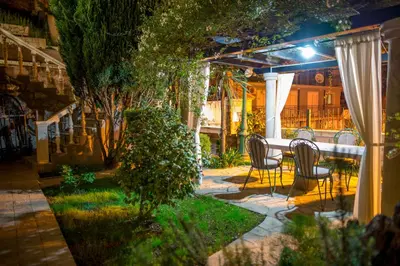 a patio with chairs and a table in a garden at night at Villa Danigo in Budva
