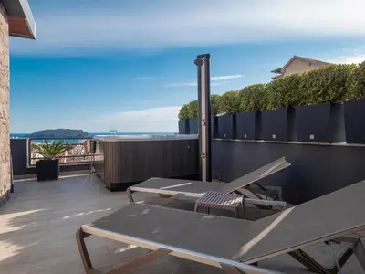 a patio with a table and chairs on a balcony at Misisuone Apartments Budva in Budva