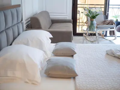 a bedroom with a bed with pillows and a couch at Misisuone Apartments Budva in Budva
