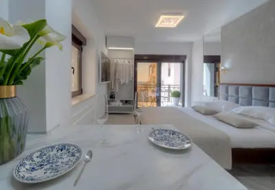 a bedroom with a large bed with two blue and white plates at Misisuone Apartments Budva in Budva