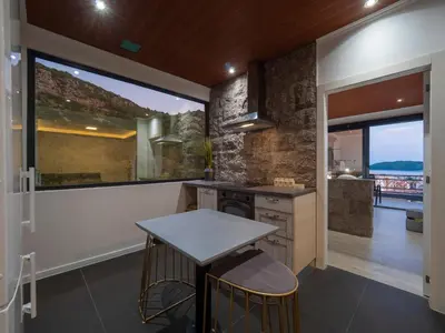 a kitchen with a table and a large window at Misisuone Apartments Budva in Budva