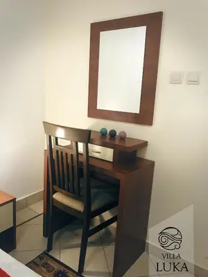 a desk with a chair and a mirror on a wall at Apartments Villa Luka in Sveti Stefan