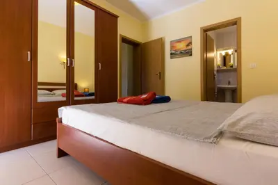 a bedroom with a large bed and a mirror at Montenegro Apartments Utjeha in Utjeha
